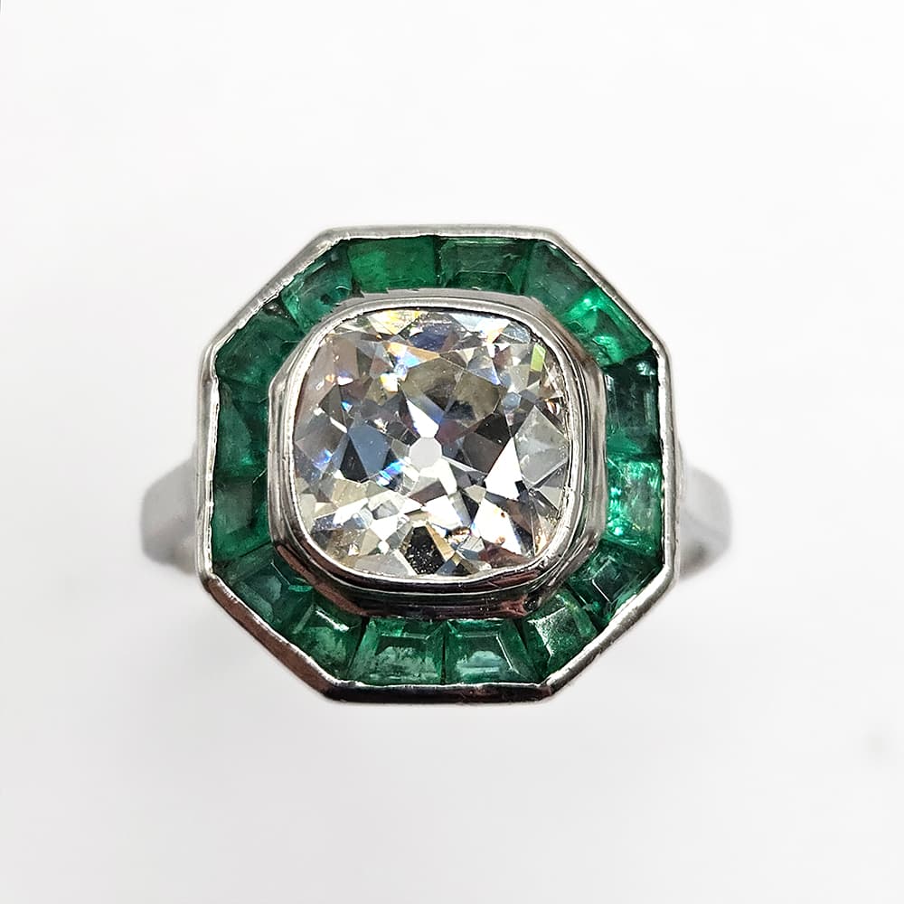 Preloved platinum ring with 1.80ct old mine cut diamond and emeralds