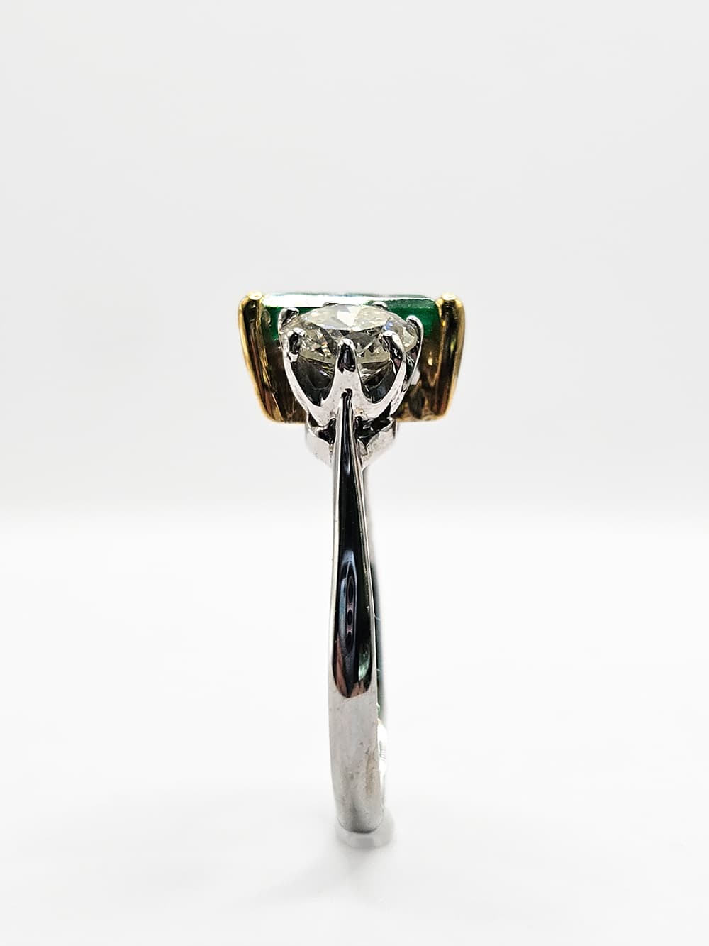 Vintage-style emerald and diamond ring in platinum side view